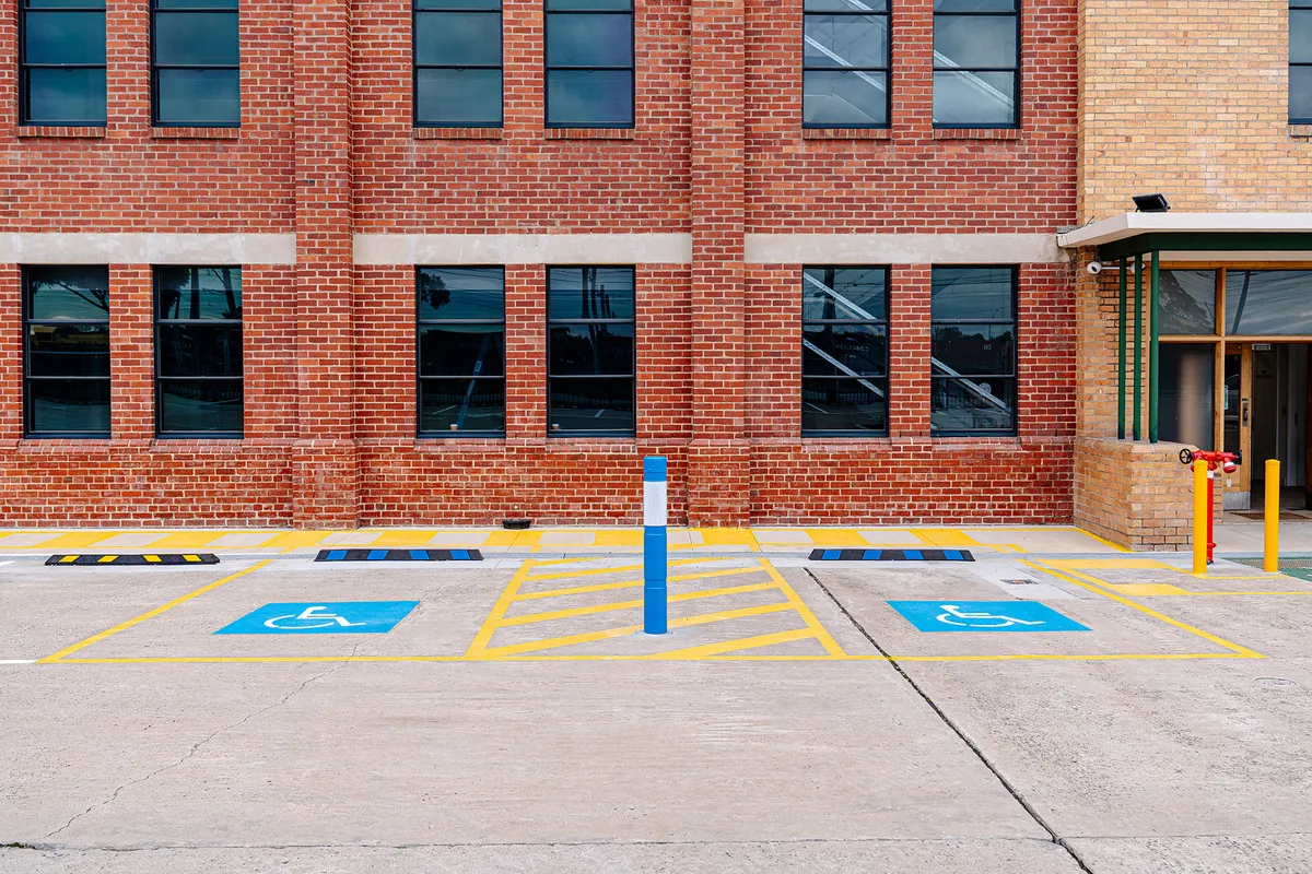 Completed accessible parking bays, shared areas and pedestrian markings at a commercial site